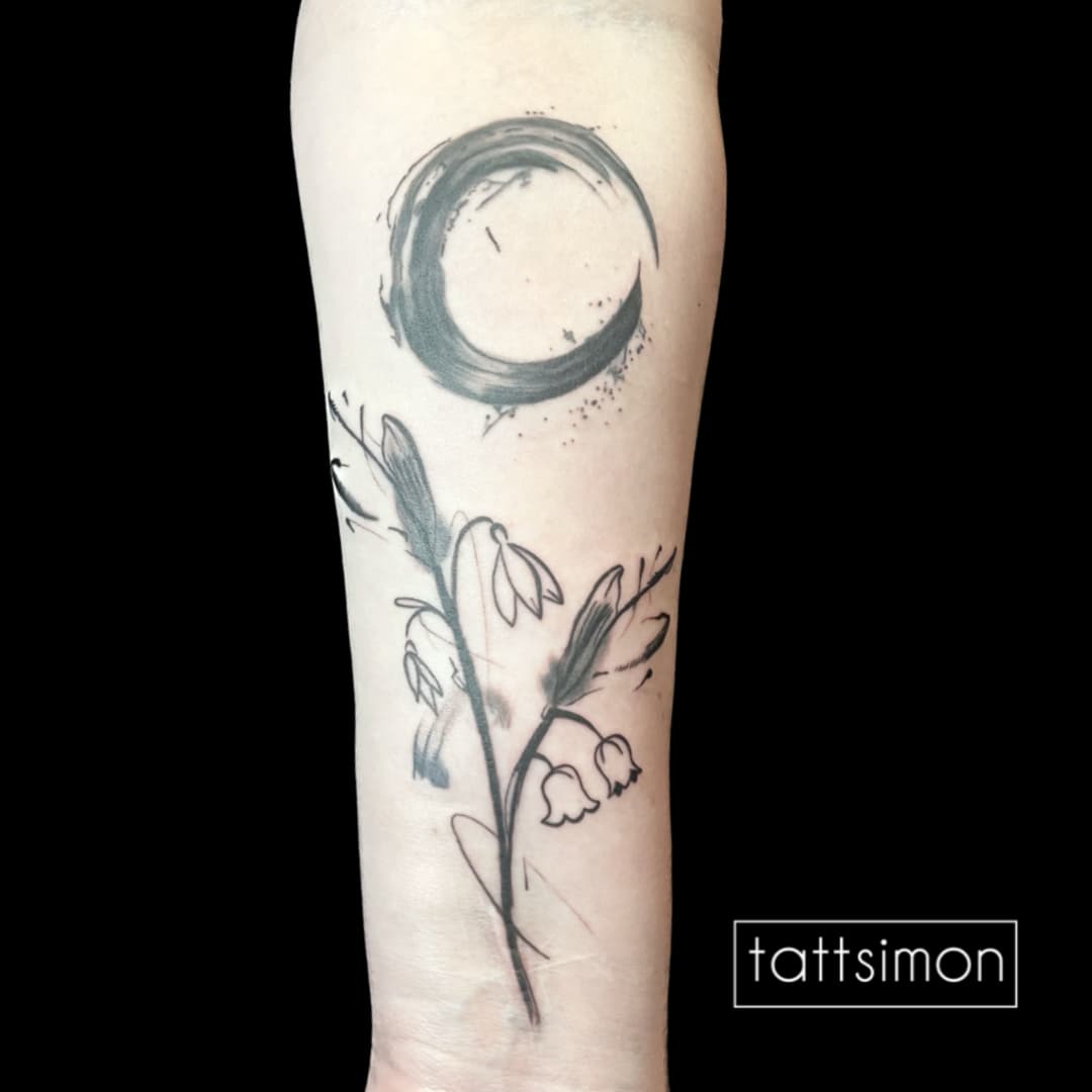 Abstraktes Tattoo: Pinselkreis mit feinen Blütenranken am Unterarm