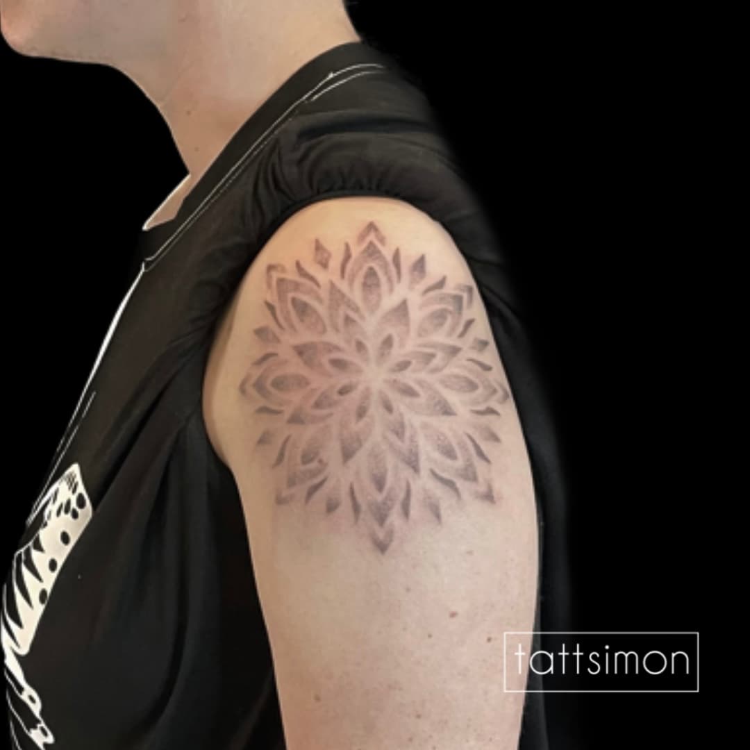 Geometrisches Linework-Tattoo eines Mandalas auf der Schulter